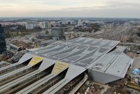 Widok z góry na dach wysokiego zadaszenia stacji i budynek dworca - fot. Artur Lewandowski