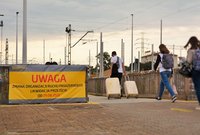 Baner zapowiadający zmiany w obsłudze podróznych na stacji Warszawa Zachodnia i ludzie z walizkami podążający do tymczasowego przejścia, fot. Martyn Janduła
