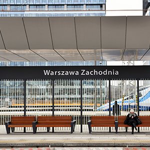 Gotowy peron nr 7 Warszawy Zachodniej, ławki, podróżna, pociąg wjeżdżający na stację.
