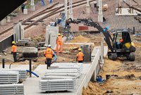 Pracownicy układają nawierzchnię nowego peronu nr 6. Koparka, fot. Martyn Janduła