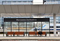 Ławki z konstrukcją ochraniającą przed wiatrem. Podróżna na ławce. Pendolino w tle, fot. Martyn Janduła