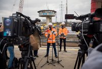 Wypowiadający się dyrektor PLK, dziennikarze i kamery na briefingu na stacji Warszawa Zachodnia, autor Łukasz Hachuła, 24.03.2021 r.