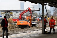Podróżni na peronie a w tle pracujące maszyny na budowie Warszawy Zachodniej, fot. Martyn Janduła