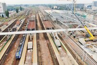 Widok z góry na konstrukcję kładki nad stacją, pociąg przy peronie. fot. Artur Lewandowski