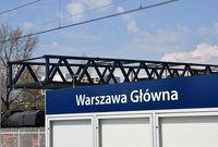 Tablica niebieska z nazwą stacji Warszawa Główna, a w tle konstrukcja kładki, fot. Martyn Janduła