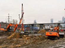 Maszyny pracujące na budowie Warszawy Zachodniej. W tle konstrukcja kładki