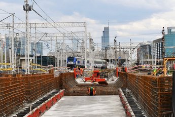 Betonowa podstawa obiektu inżynieryjnego. W tle widoczny pociąg i elementy sieci trakcyjnej fot. Martyn Janduła