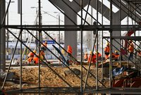 Widok na pracowników układających nawierzchnię peronów. Rurki rusztowania, fot. Martyn Janduła