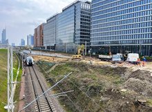 Wykonawcy i maszyny na placu budowy połączenia linii dalekobieżnej z podmiejską, w tle wieżowce Warszawy, widać pociąg, fot. Anna Znajewska-Pawluk (2)